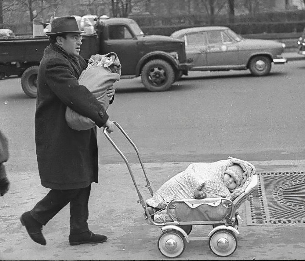 Фотограф Виктор Ахломов снял на улице Москвы мужчину, который вез одного ребенка в коляске, а другого держал на руках